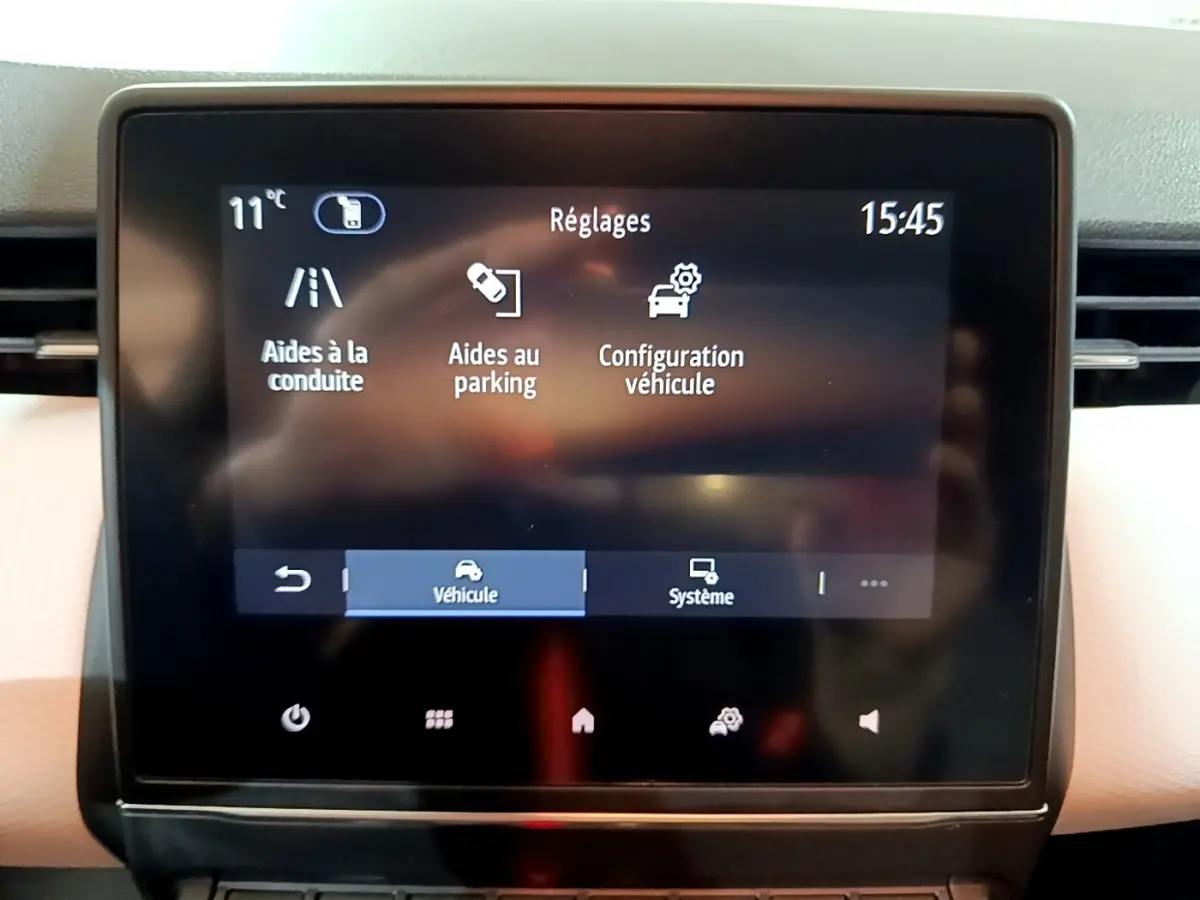 Écran tactile central de la Renault Clio Business blanc, affichant le menu réglages aides à la conduite et parking.