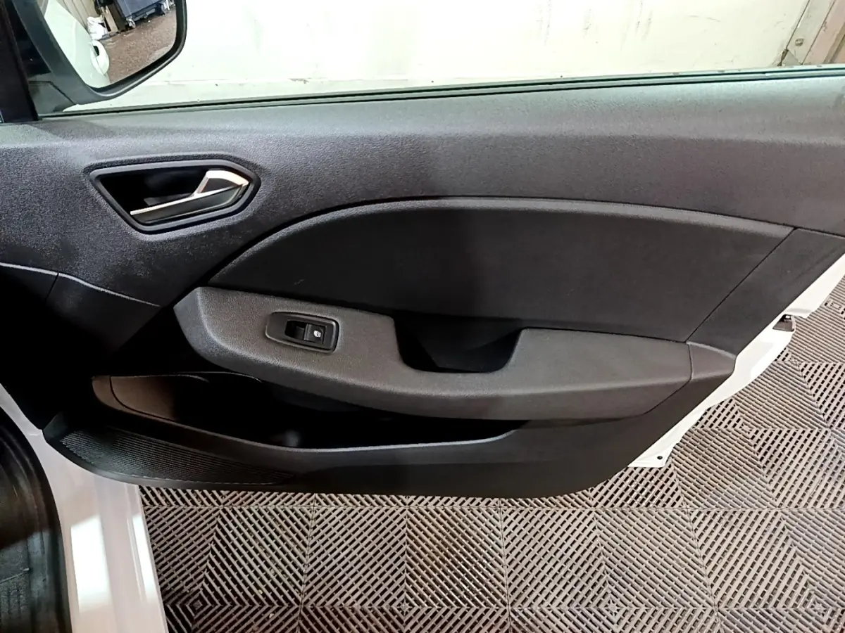 Vue intérieure côté gauche de la porte avant noire d’une Renault Clio Business blanche avec commande de vitre électrique.