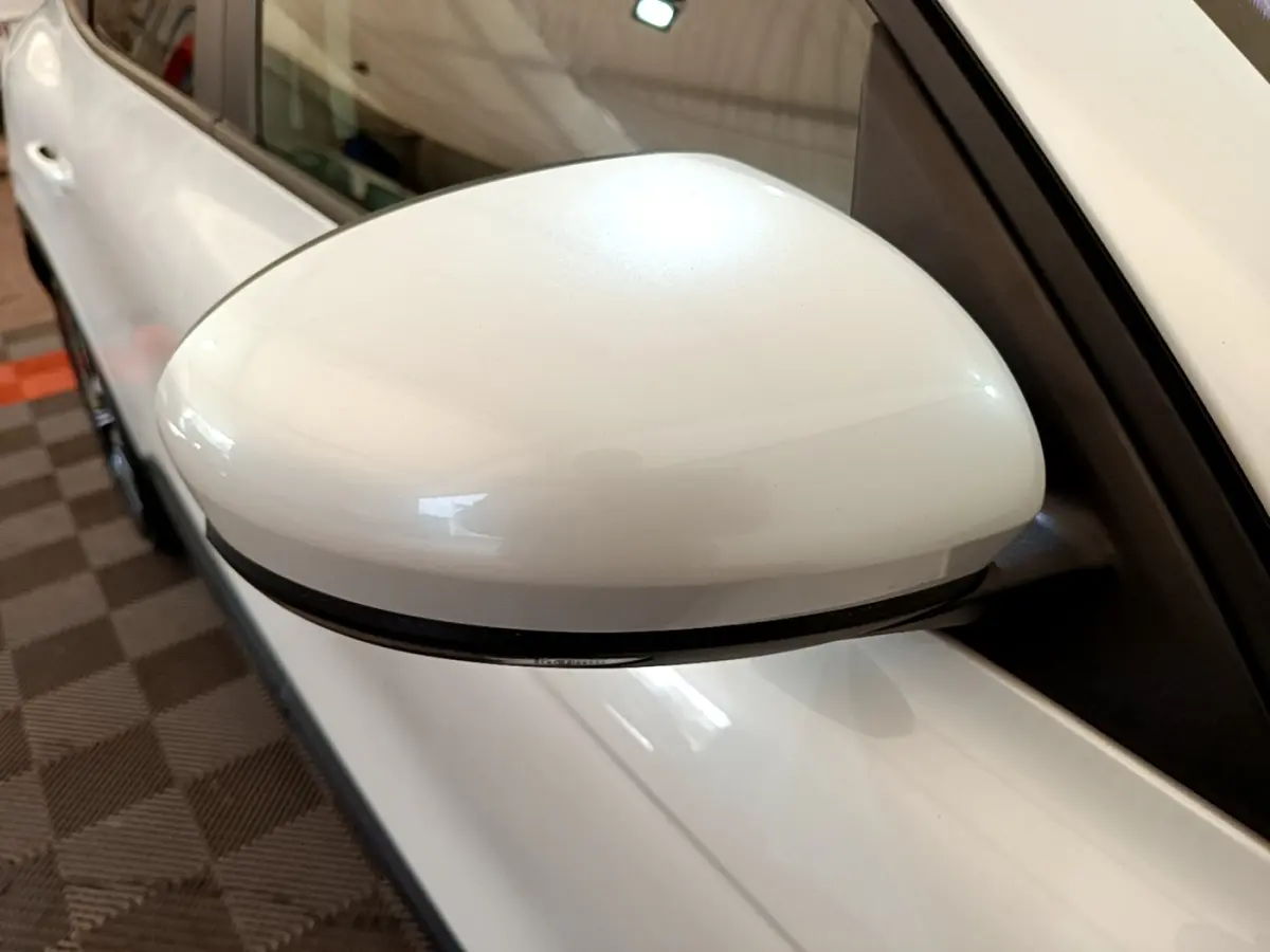 Rétroviseur côté gauche blanc du Renault Arkana Evolution E-Tech 145, vue rapprochée en intérieur.