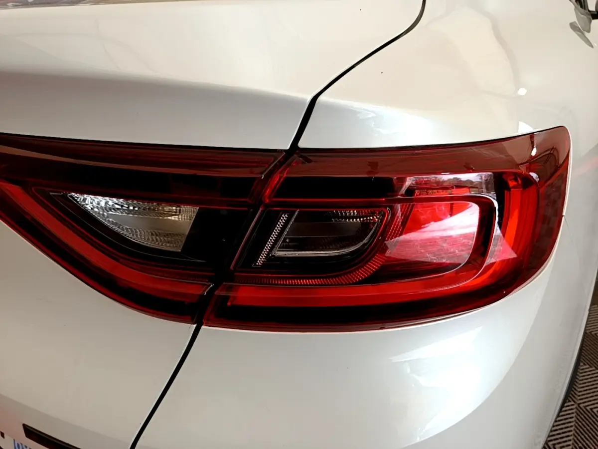 Gros plan sur le feu arrière droit rouge et blanc du Renault Arkana blanc Evolution E-Tech 2023.