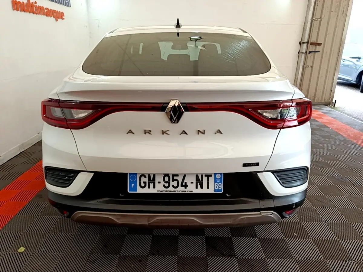 Vue arrière d'une Renault Arkana blanche 2023 avec feux LED reliés et logo centré sur le coffre.