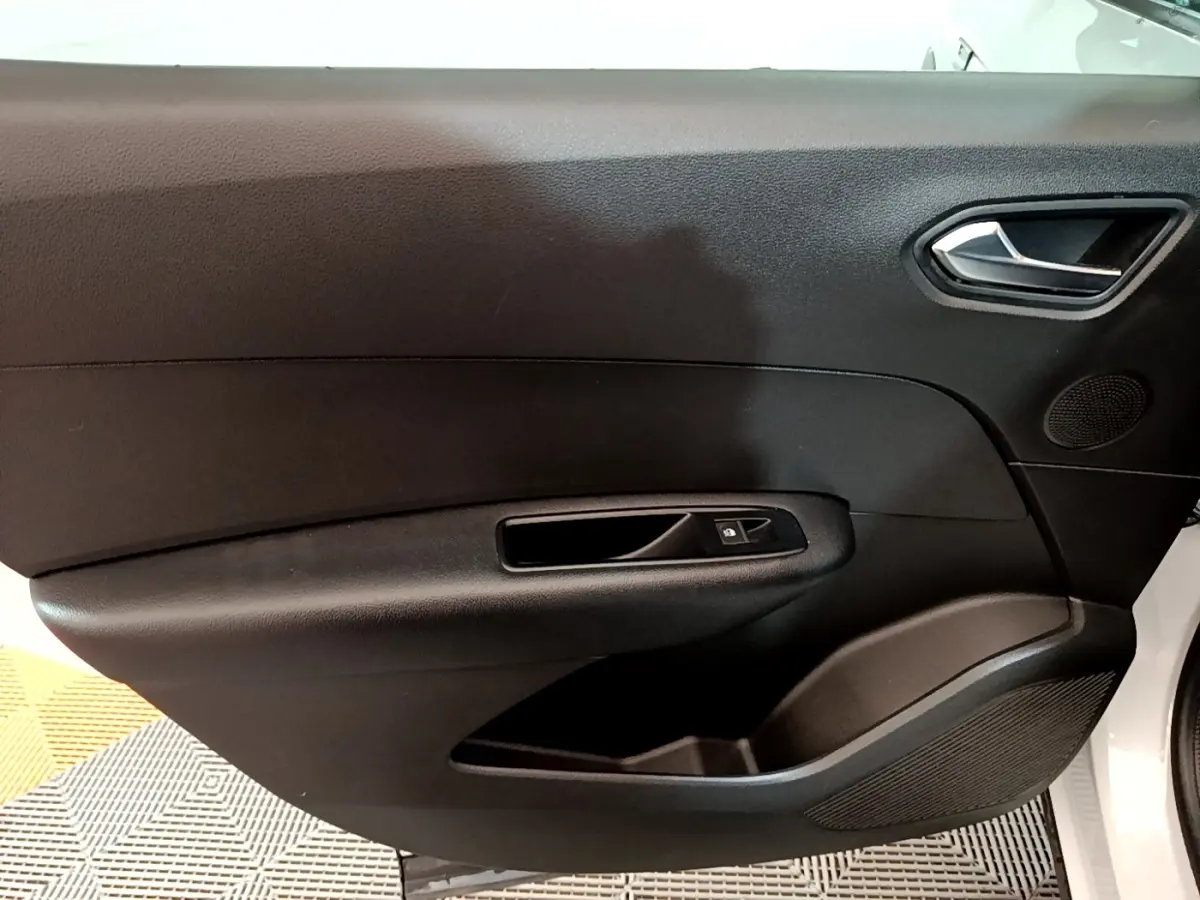 Gros plan sur la porte intérieure côté conducteur du Renault Arkana blanc, avec poignée et commande de vitre noire.