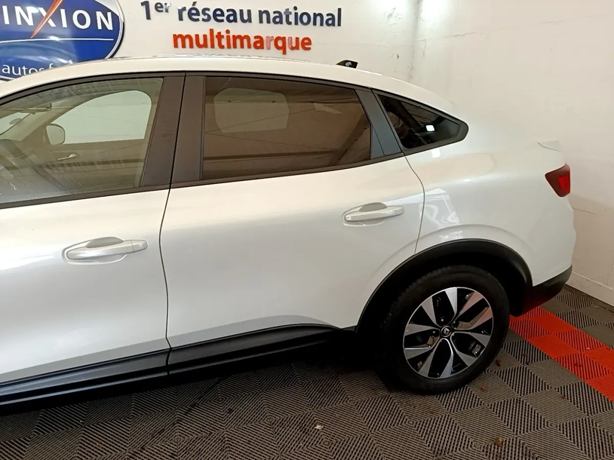 Vue latérale côté droit du Renault Arkana blanc, mettant en valeur la ligne fluide et les jantes modernes.