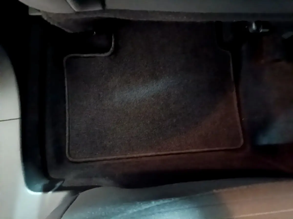 Tapis de sol noir côté conducteur du Renault Arkana blanc, vue rapprochée de l'intérieur au sol.