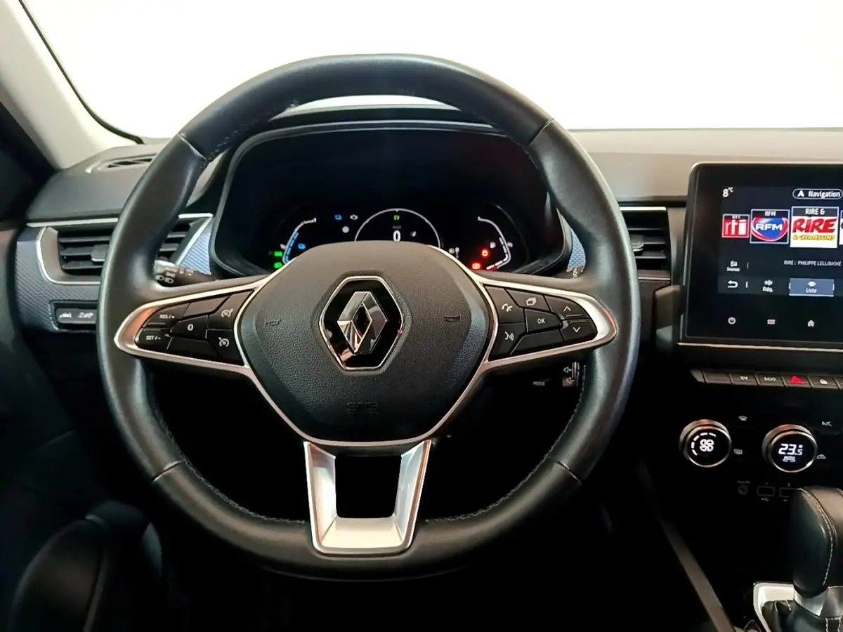 Vue frontale du volant noir en cuir du Renault Arkana 2023 avec tableau de bord numérique et écran tactile central.