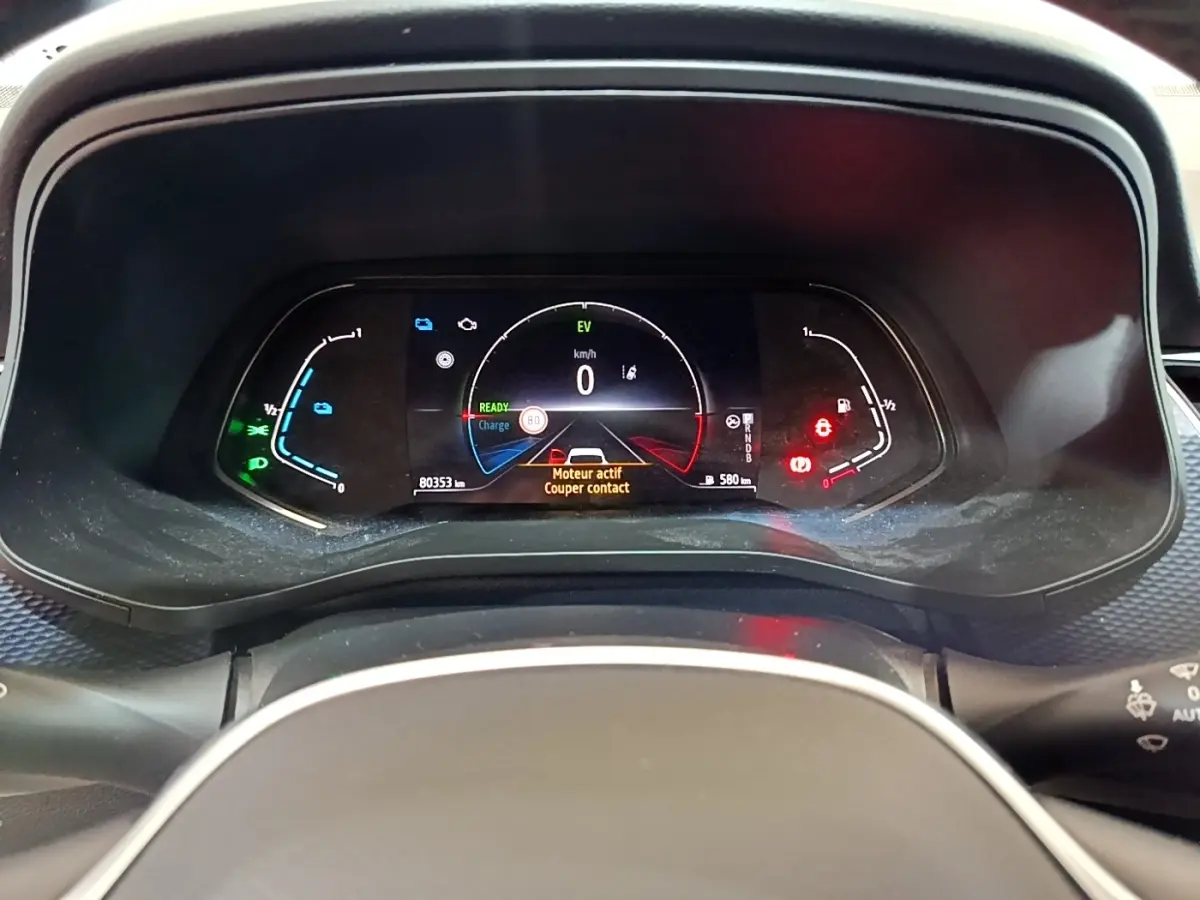 Vue rapprochée du combiné d'instruments numérique du Renault Arkana blanc, affichant les alertes et indicateurs hybrides.