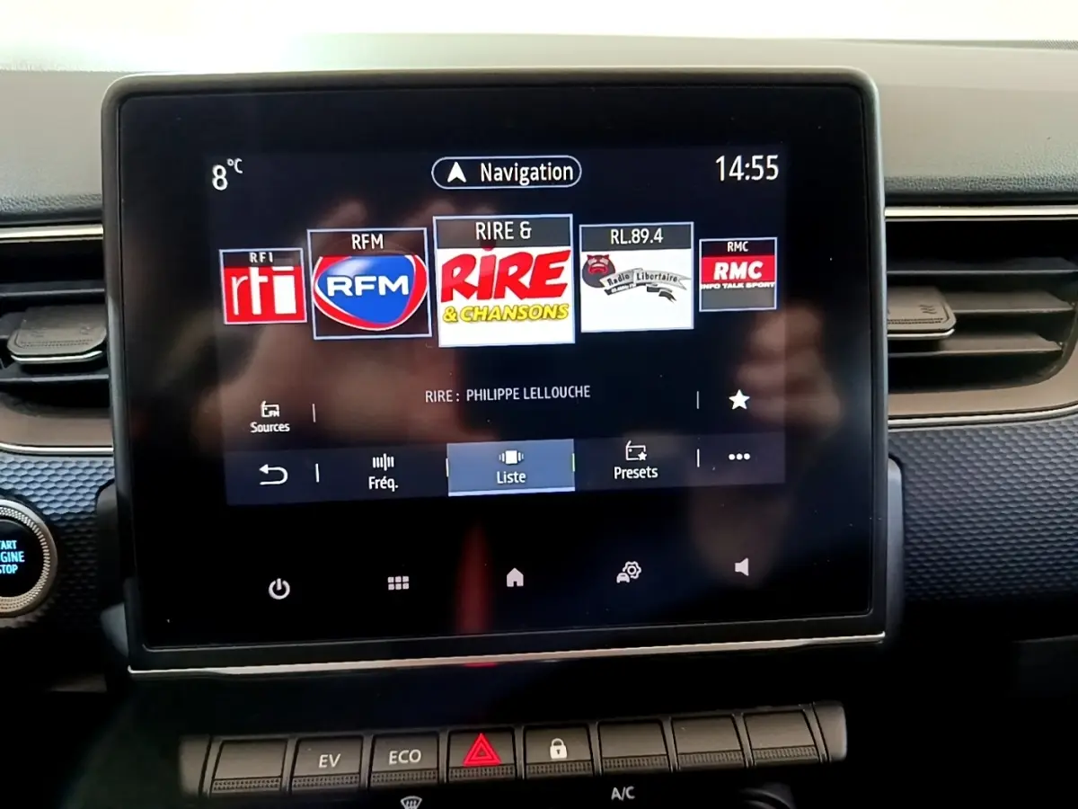 Écran tactile central du tableau de bord de la Renault Arkana blanc, affichant les radios en mode navigation.