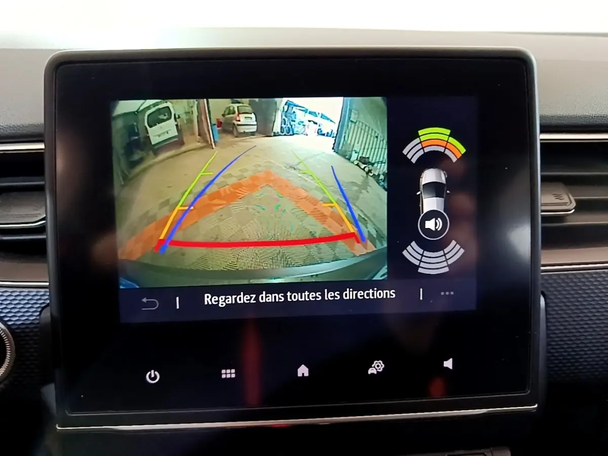 Écran tactile central montrant la caméra de recul avec guidage coloré sur Renault Arkana blanc, vue intérieure.