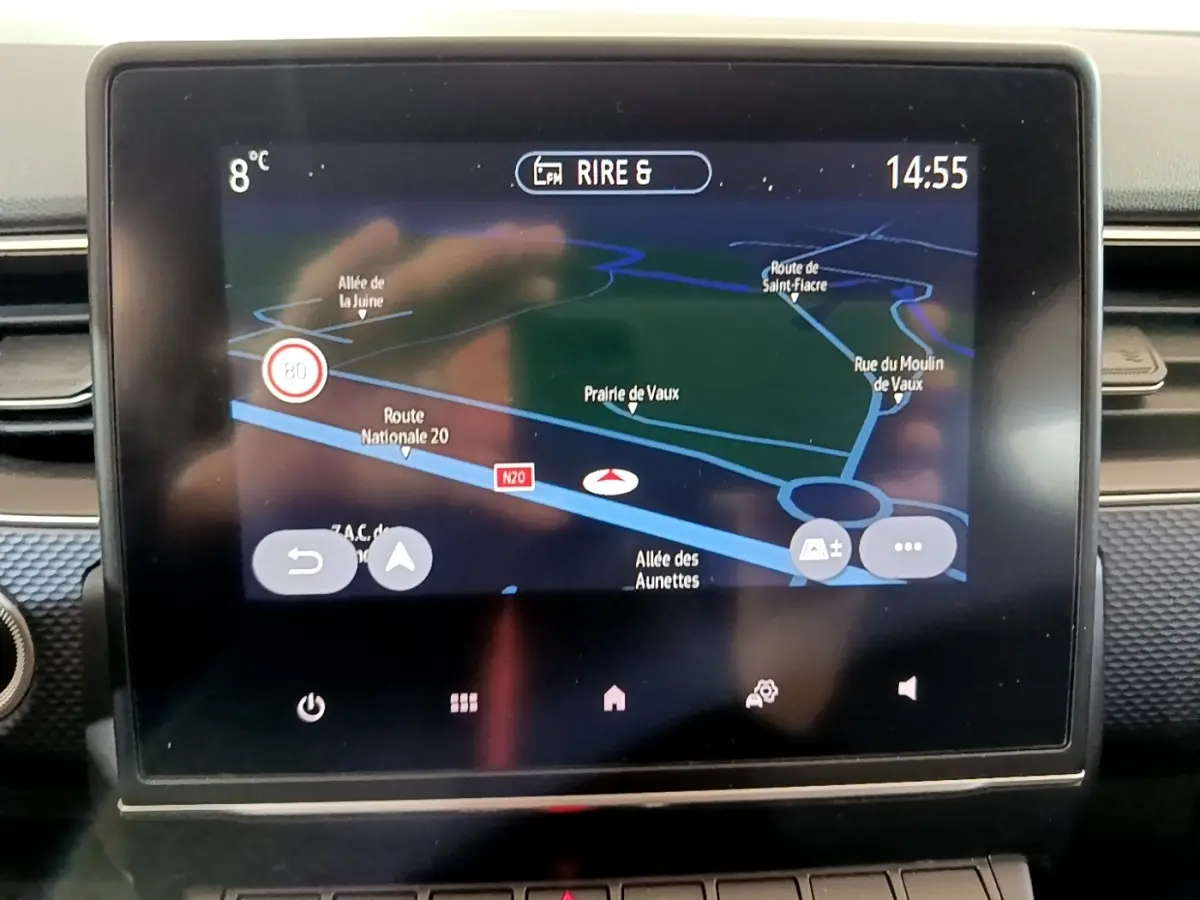 Écran tactile central du tableau de bord du Renault Arkana blanc, affichant la navigation 3D en plein jour.