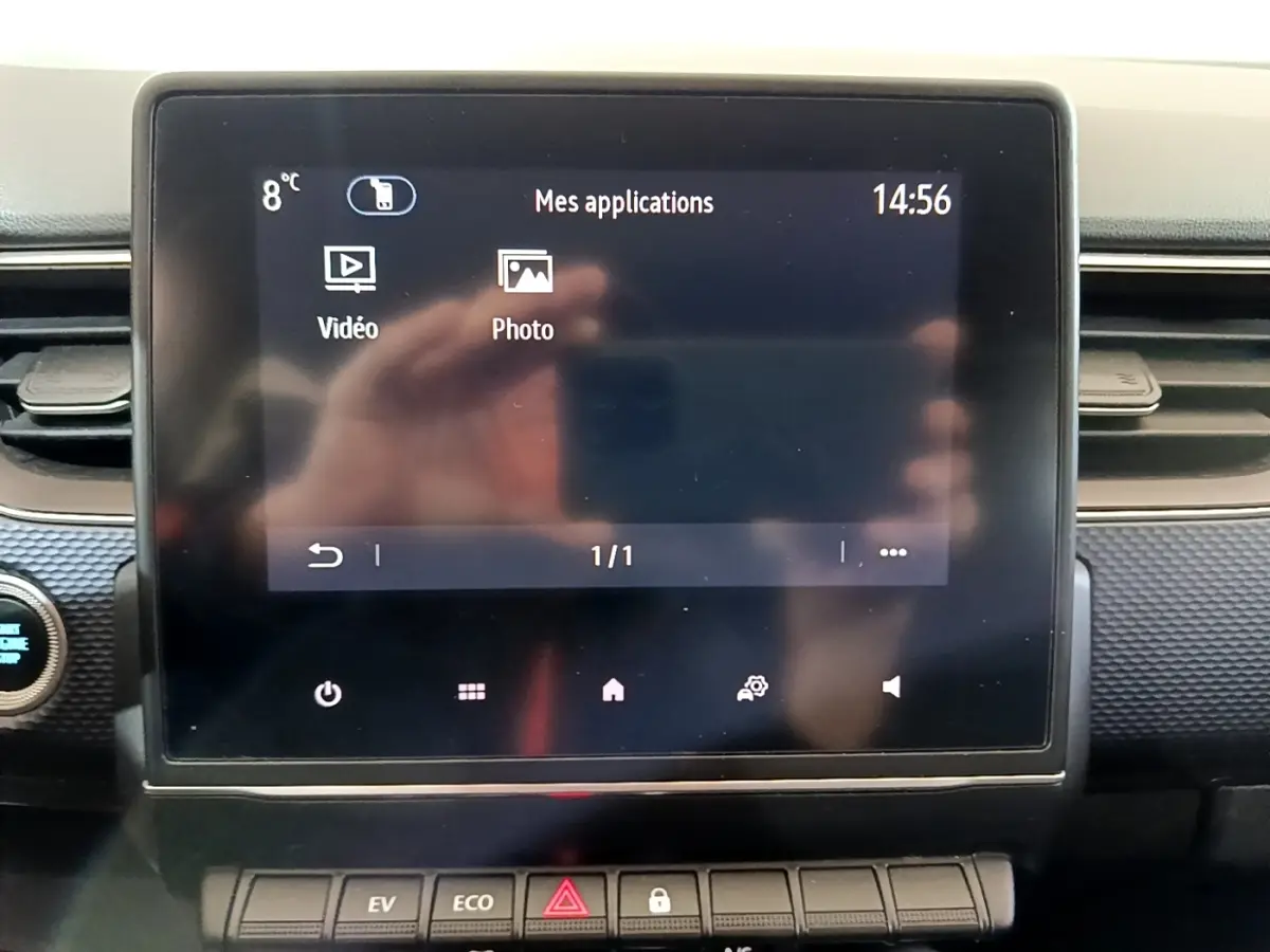 Écran tactile central du tableau de bord du Renault Arkana blanc, vue frontale rapprochée avec commandes en dessous.