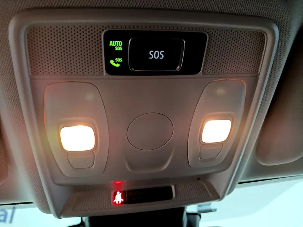 Vue intérieure en gros plan du plafonnier avec boutons d’éclairage et alerte SOS allumée dans une Renault Arkana blanche.