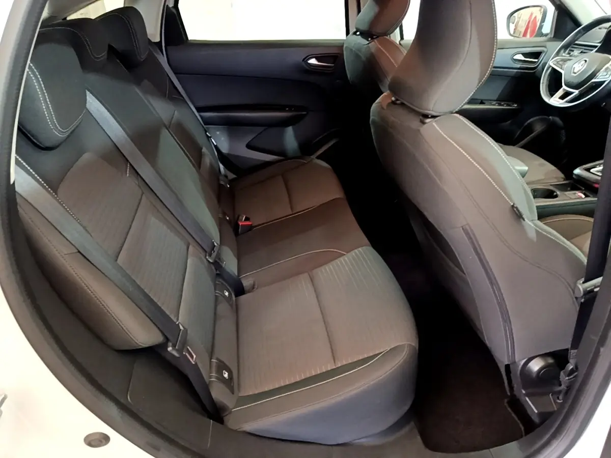 Vue intérieure côté arrière droit du Renault Arkana blanc 2023, montrant les sièges arrière en tissu gris foncé avec surpiqûres claires.