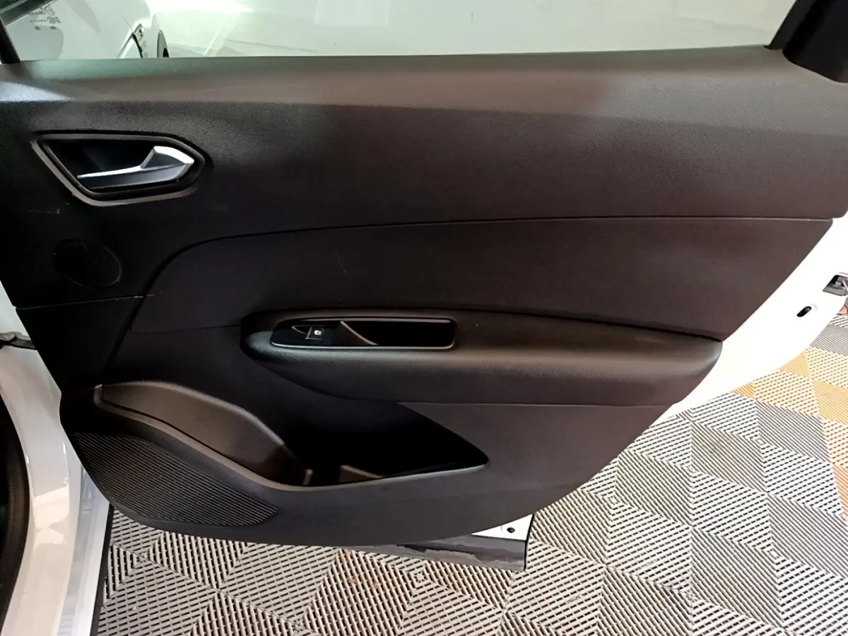 Vue intérieure de la porte arrière gauche noire du Renault Arkana blanc, avec poignée et commande de vitre intégrée.