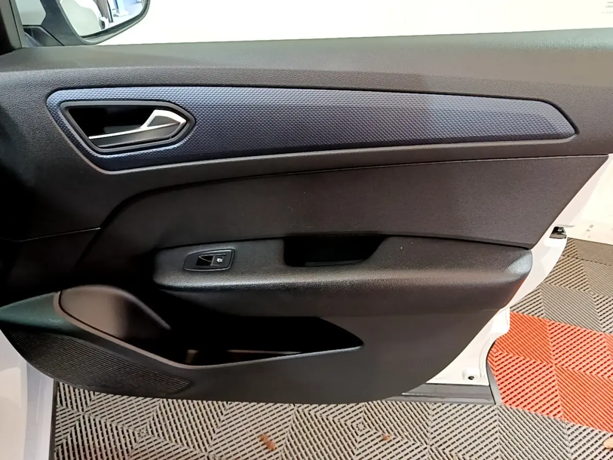 Vue intérieure côté gauche de la porte avant blanche du Renault Arkana avec poignée argentée et habillage noir texturé.