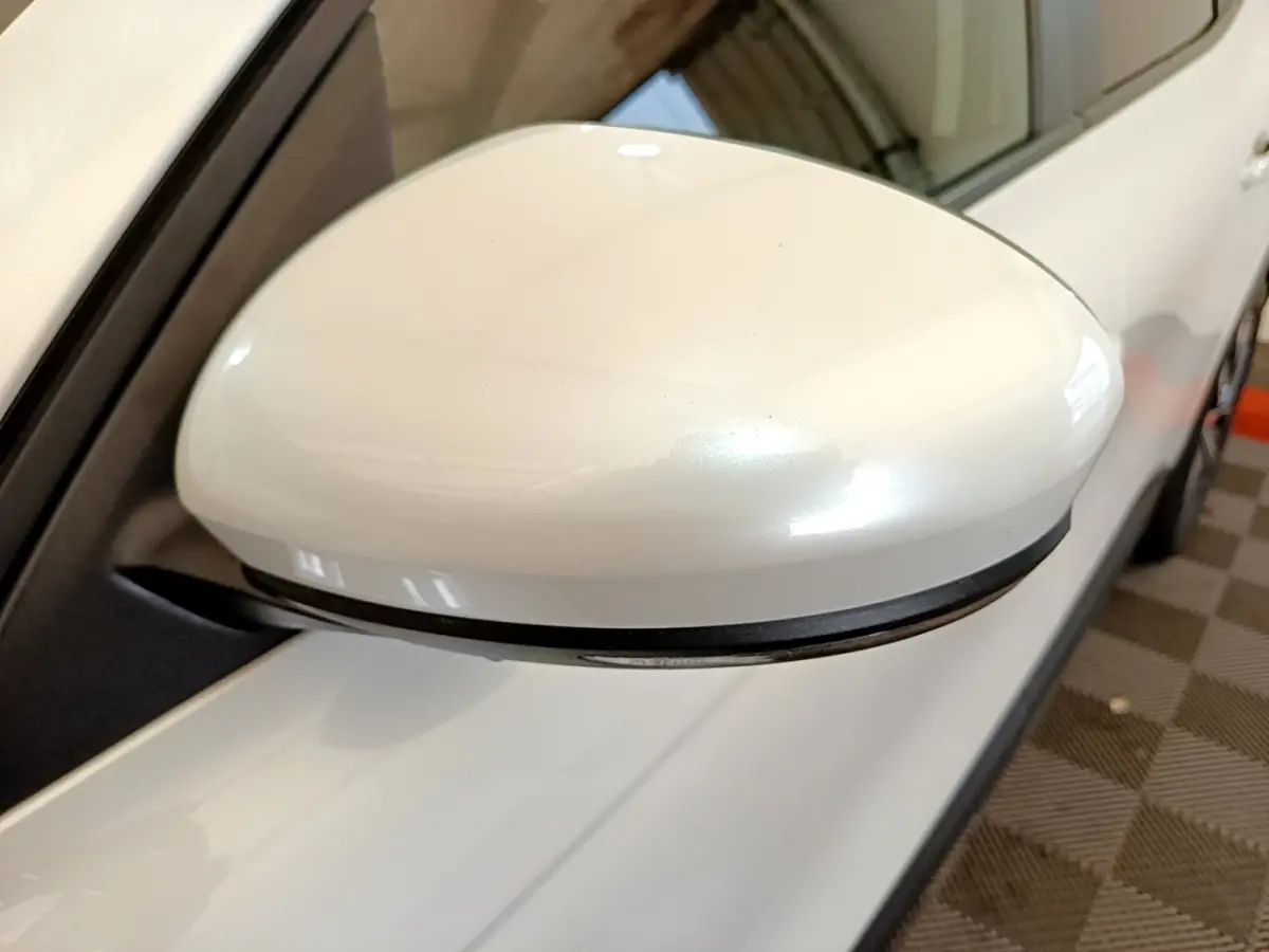 Rétroviseur droit blanc du Renault Arkana Evolution E-Tech 145, vue rapprochée côté extérieur avec carrosserie visible.