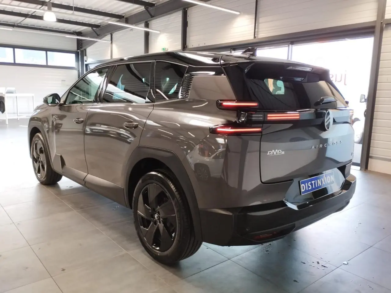 Vue 3/4 arrière droite du Citroën C5 Aircross gris métallisé avec feux arrière LED et jantes alliage noires.