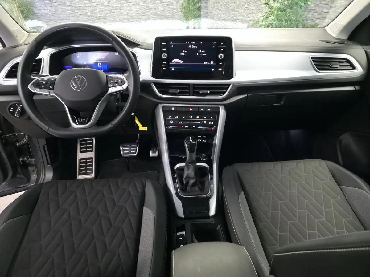 Vue intérieure frontale du tableau de bord et volant cuir multifonction du Volkswagen T-Roc gris édition Life Plus 2025.