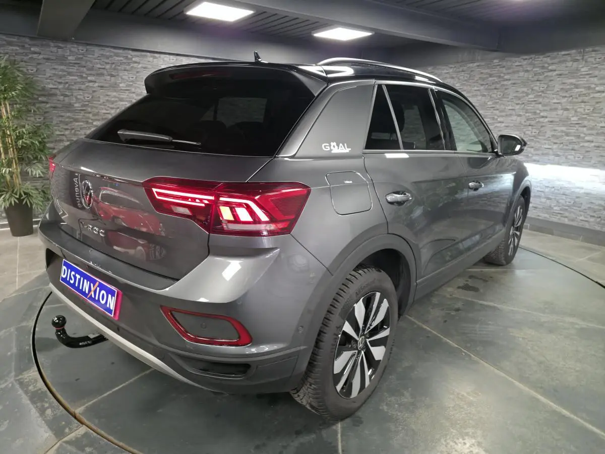 Vue 3/4 arrière droite du Volkswagen T-Roc gris métallisé avec attelage démontable et jantes alliage 17 pouces.