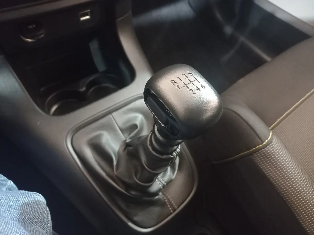 Gros plan sur le levier de vitesses manuel noir de la Citroën C3 2024, avec sellerie marron visible à droite.
