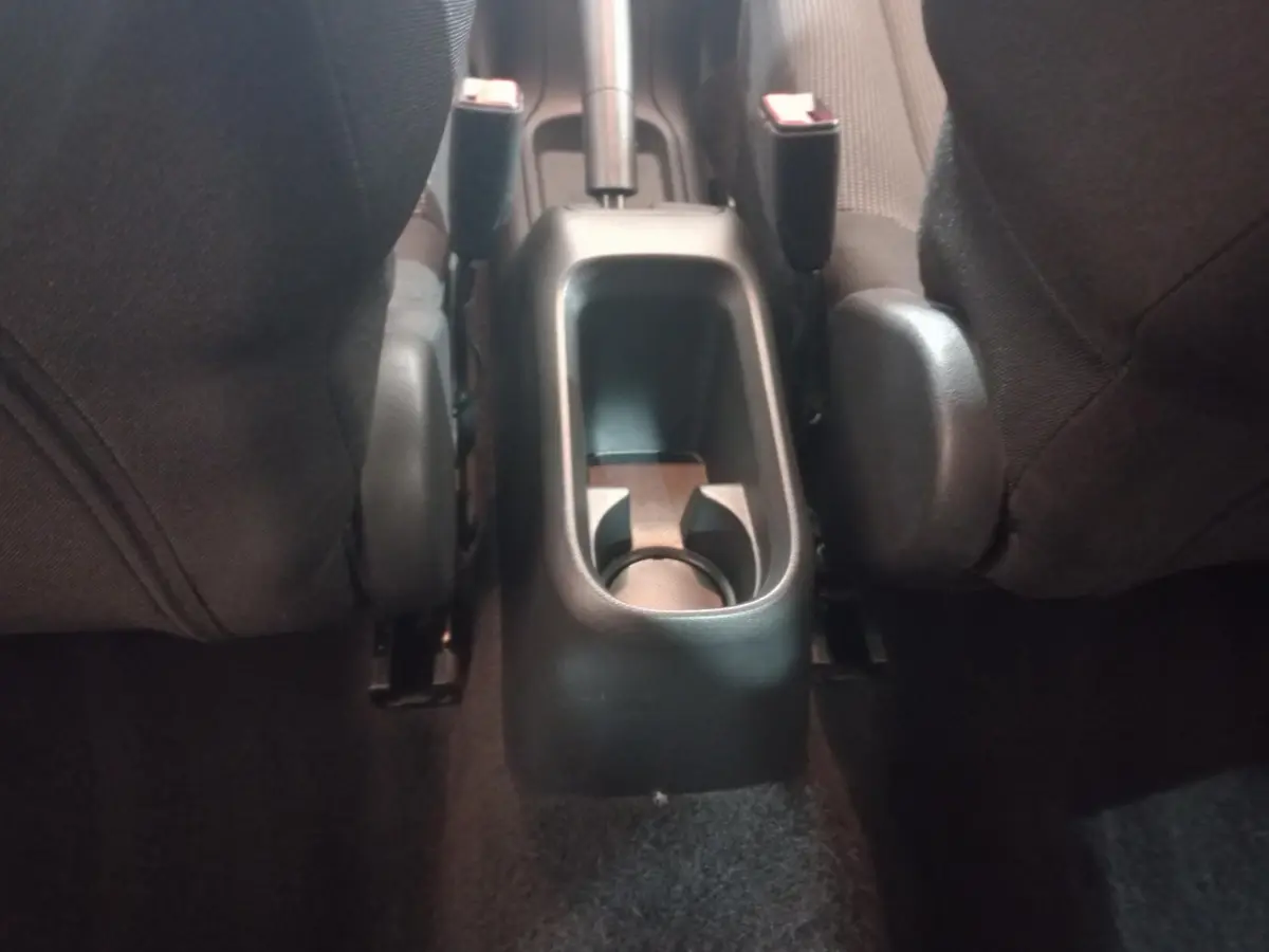 Vue rapprochée de la console centrale arrière noire entre les sièges avant d'une Citroën C3 2024.
