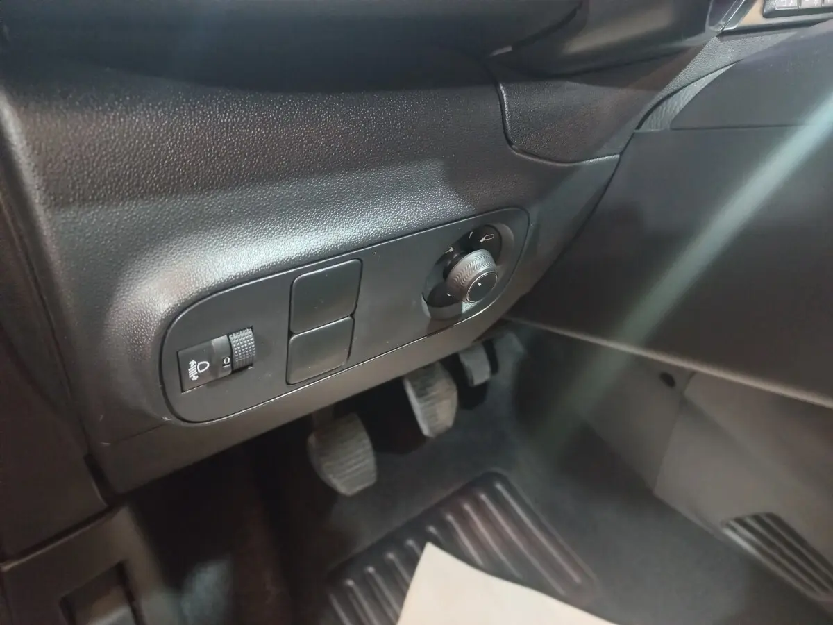 Vue intérieure côté conducteur du Citroën C3 noir 2024, avec commandes d’éclairage et pédales visibles.