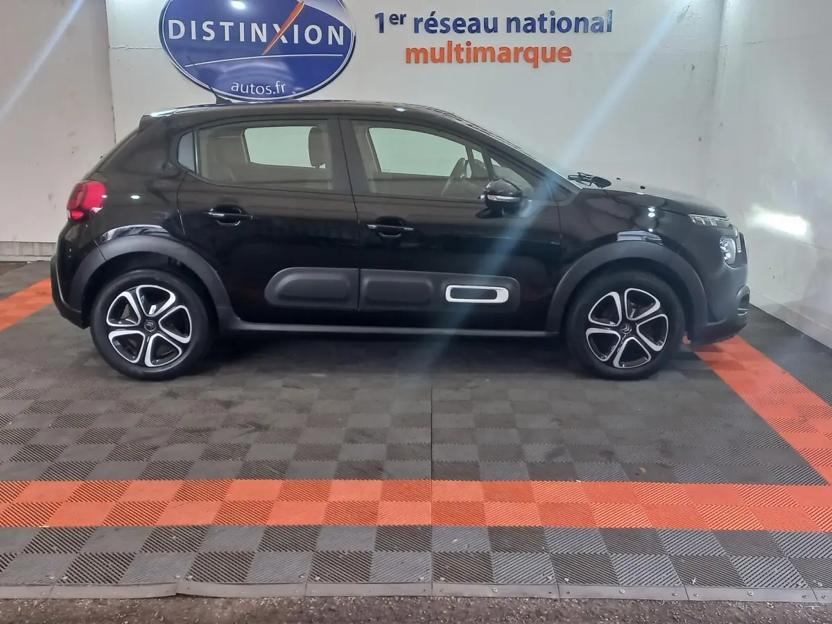 Profil droit d'une Citroën C3 noire 2024 avec protections latérales caractéristiques et jantes stylisées.