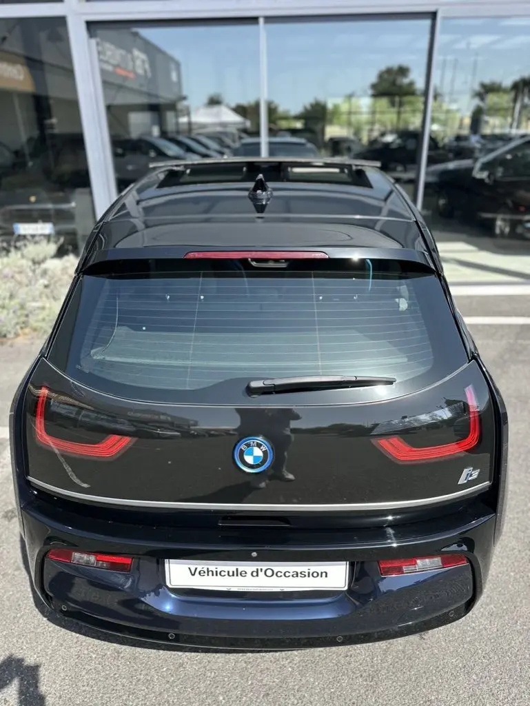 Vue arrière d'une BMW i3 électrique bleue 2022 avec feux LED caractéristiques et logo BMW bien visibles.