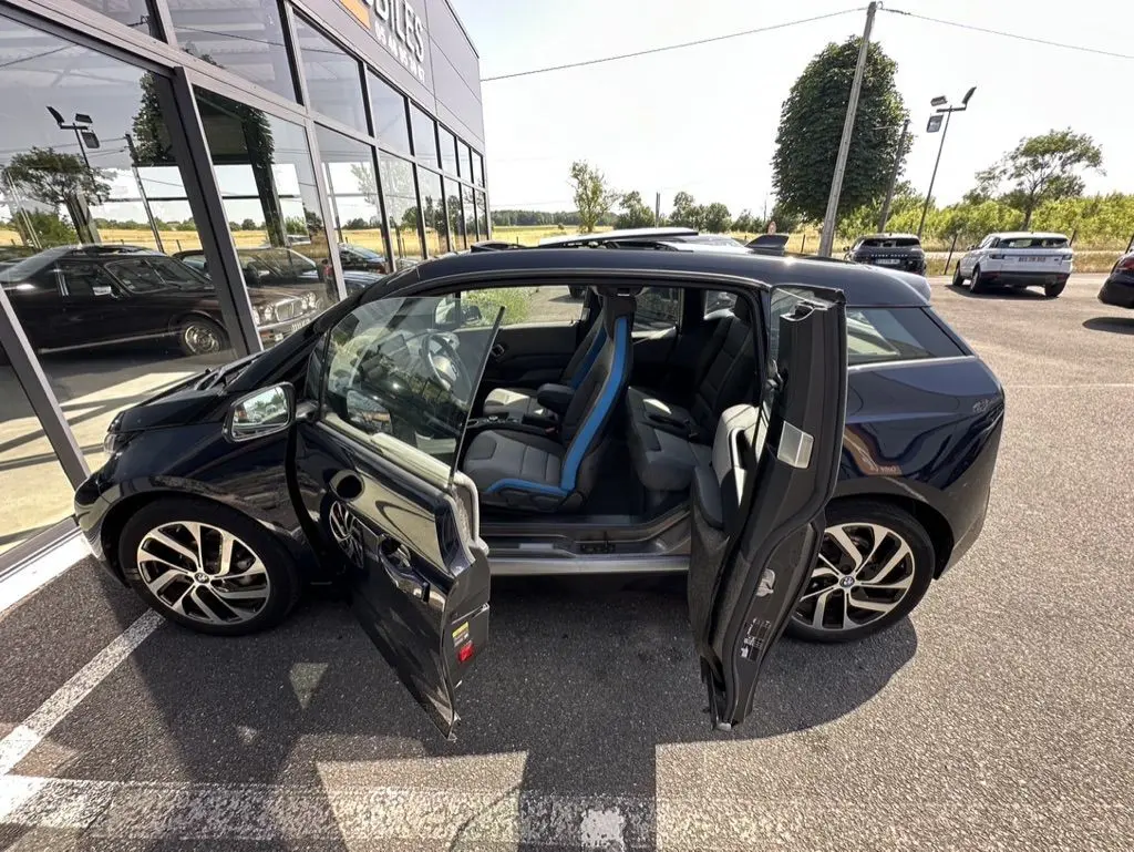 BMW i3 électrique bleue vue de profil gauche avec portes avant et arrière ouvertes montrant l'intérieur.
