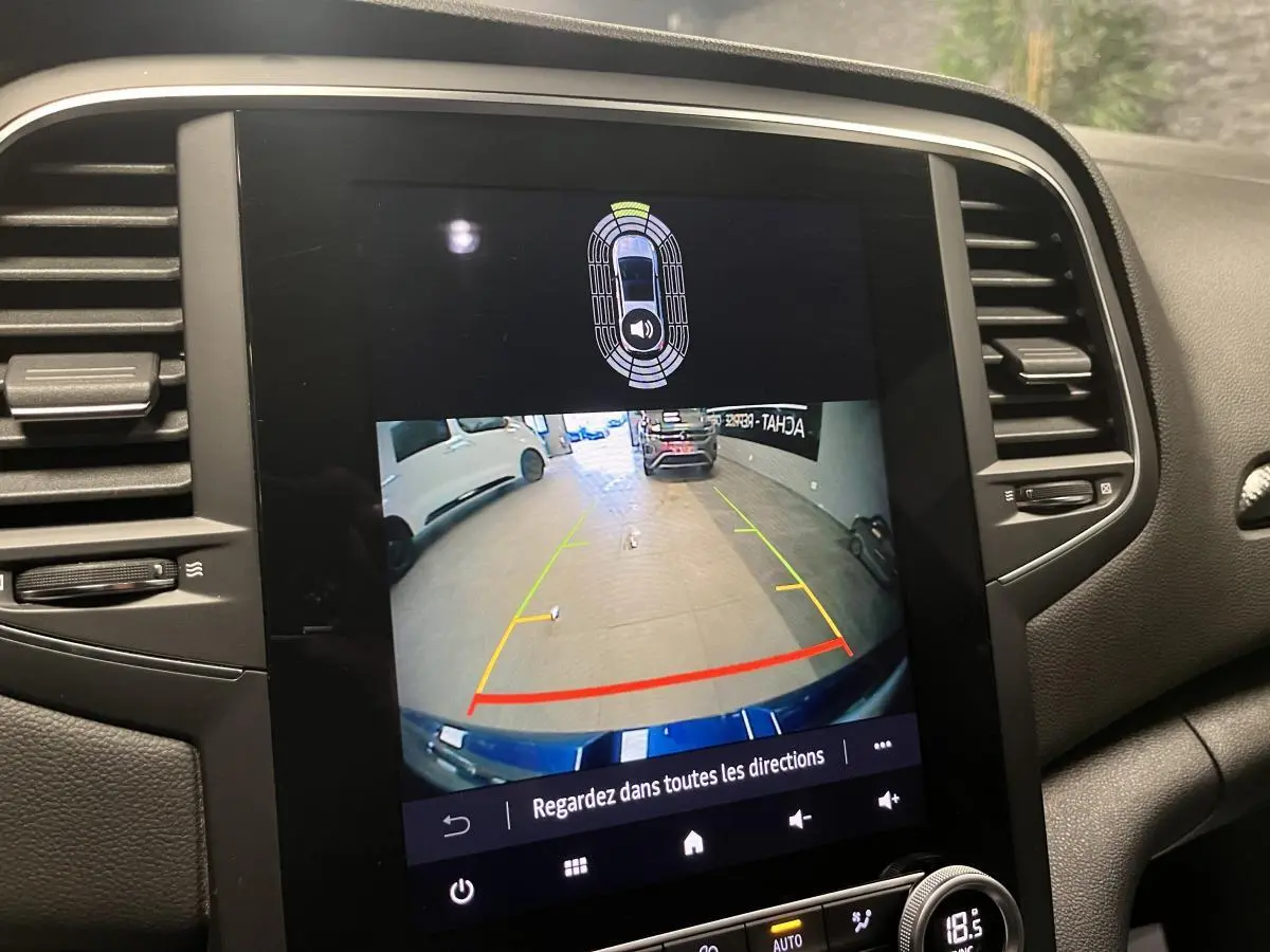 Écran central de la Renault Mégane hybride affichant la caméra de recul avec guidage de trajectoire coloré.