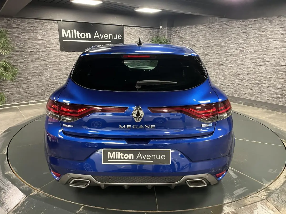 Vue arrière d'une Renault Mégane 1.6 E-Tech Plug-in Hybride bleu Iron avec double sortie d'échappement chromée.