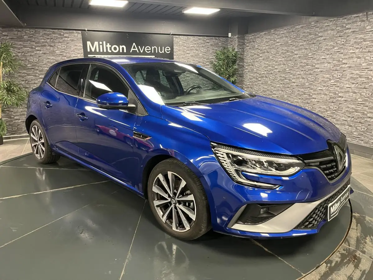 Vue 3/4 avant droite de la Renault Mégane hybride rechargeable bleu Iron avec jantes alliage et calandre sport.