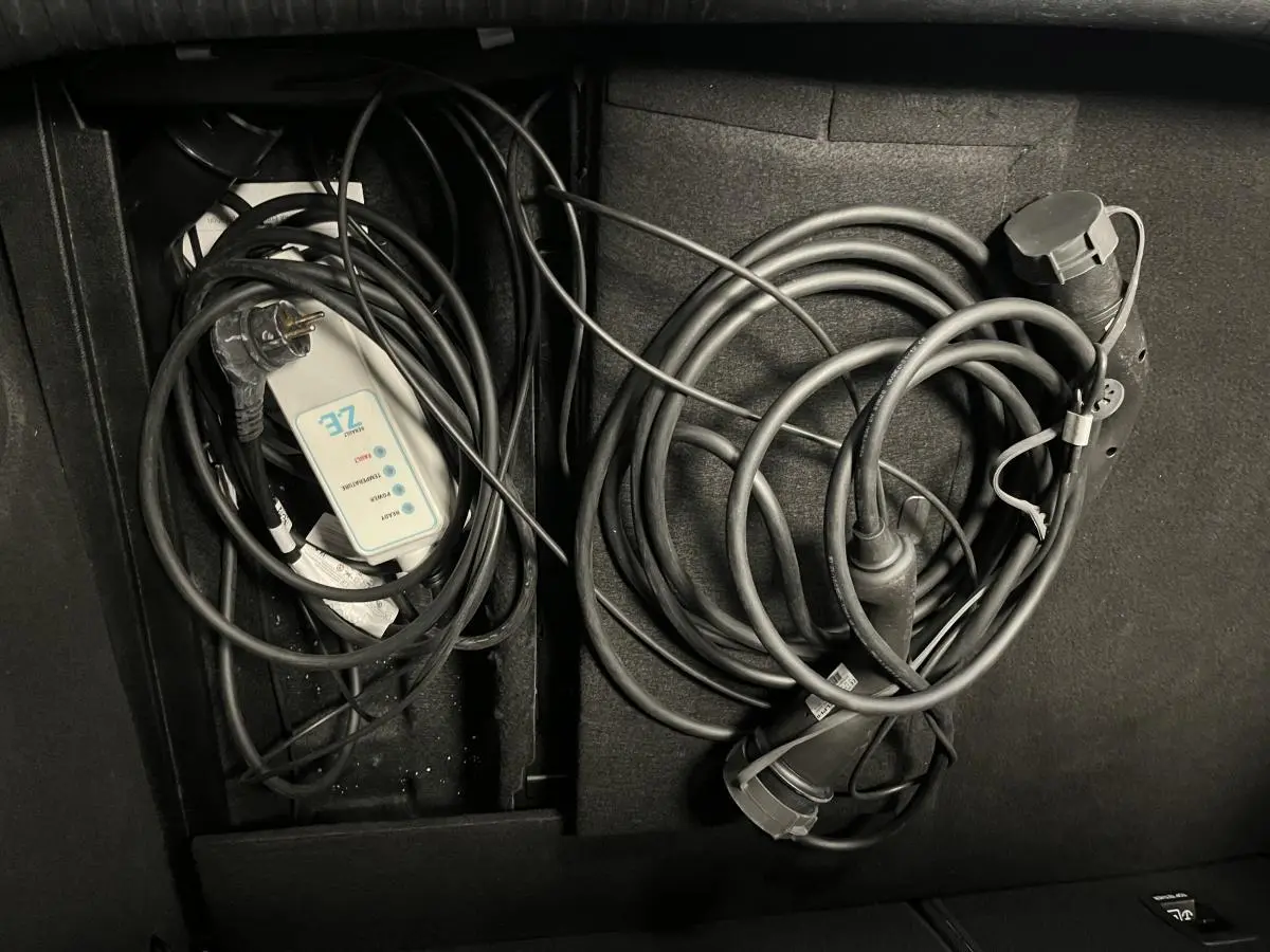 Coffre de Renault Mégane hybride 2021 avec câbles de recharge Flexicharger et Wallbox rangés.