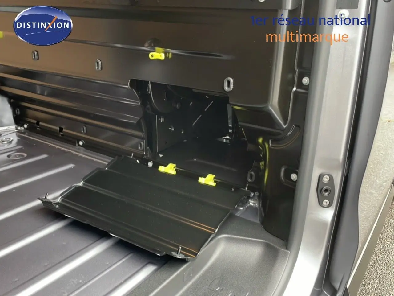 Détail intérieur du coffre côté droit du Citroën Jumpy gris Artense Metal avec compartiment de rangement ouvert.