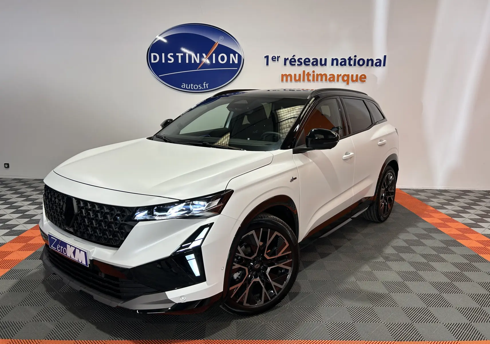 Renault Austral blanc nacré satin vu 3/4 avant droit avec toit noir et jantes noires bicolores.