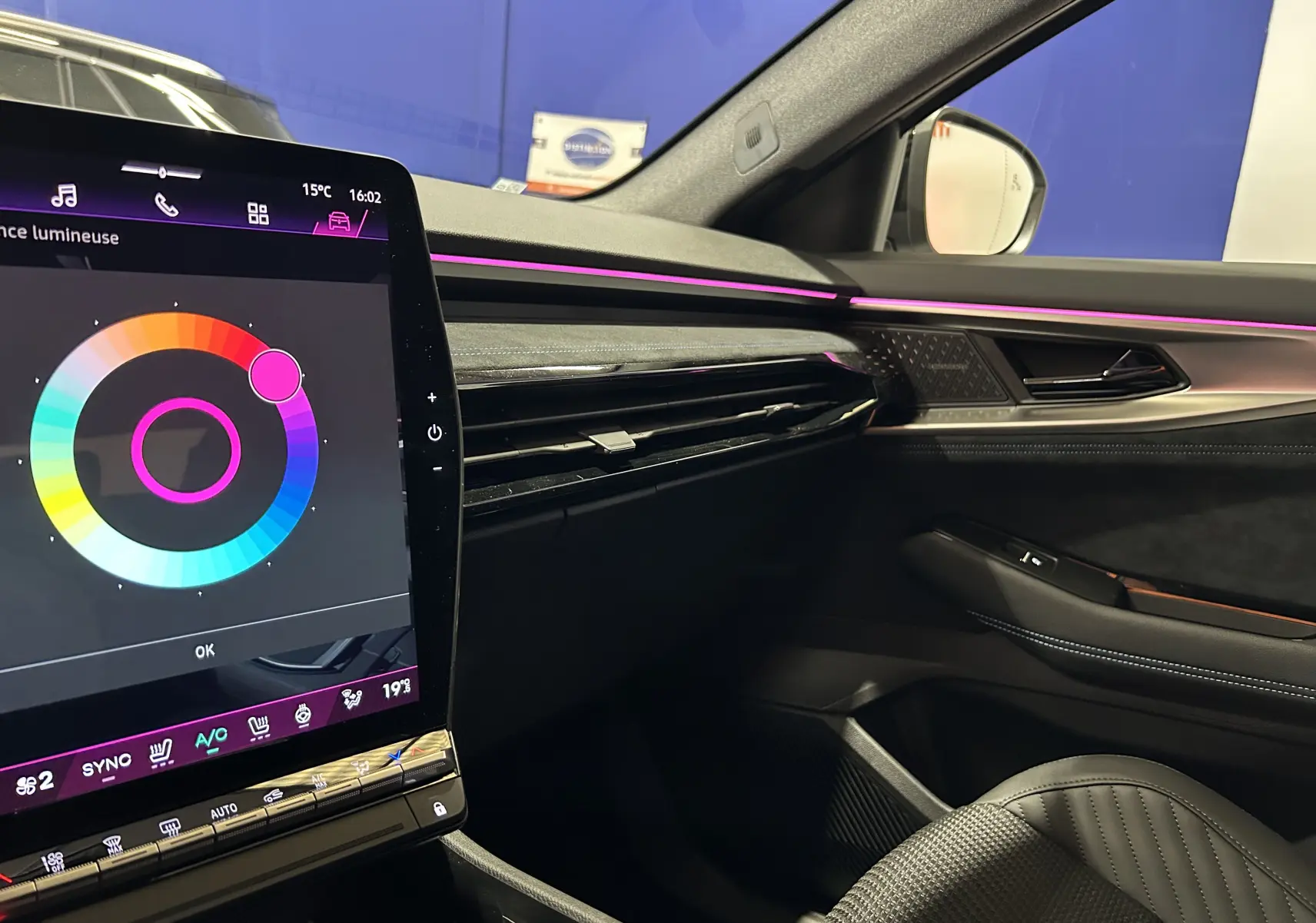 Vue intérieure côté passager du Renault Austral Ph.2 E-TECH avec éclairage d’ambiance violet et sellerie cuir noire.