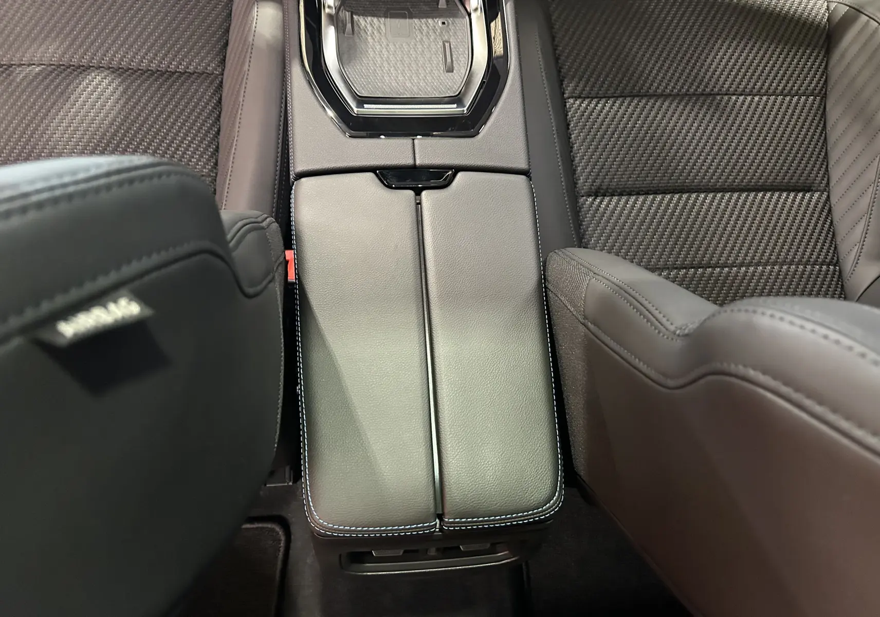 Vue rapprochée du tunnel central en cuir gris et surpiqûres blanches entre les sièges avant du Renault Austral.