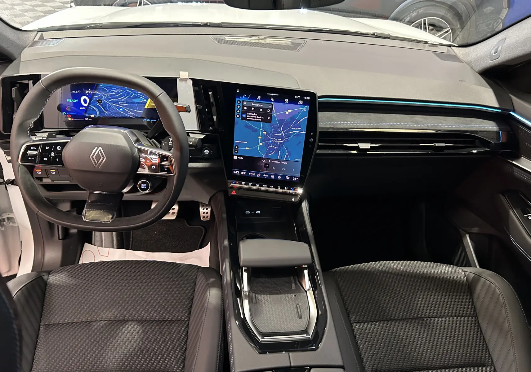 Vue intérieure avant du Renault Austral Ph.2 E-TECH avec tableau de bord numérique et écran tactile central vertical.
