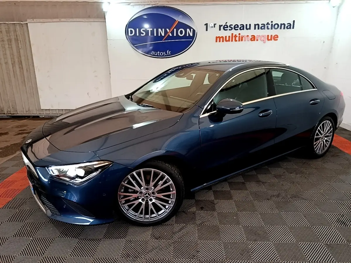 Vue 3/4 avant droite d'une Mercedes Classe CLA bleu métallisé avec jantes alliage multibranches dans un showroom.