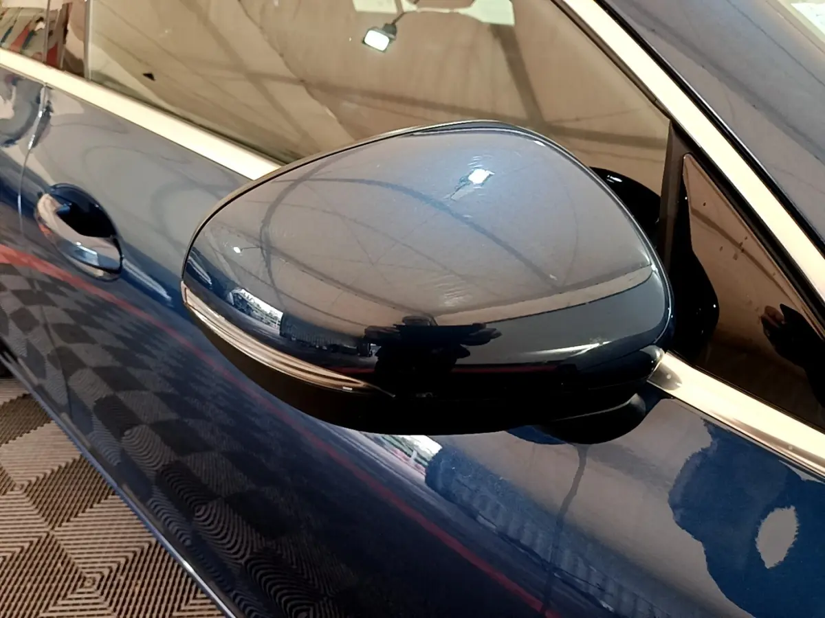 Rétroviseur côté gauche bleu foncé d'une Mercedes CLA 180 d Business Line, vue rapprochée sur la portière.