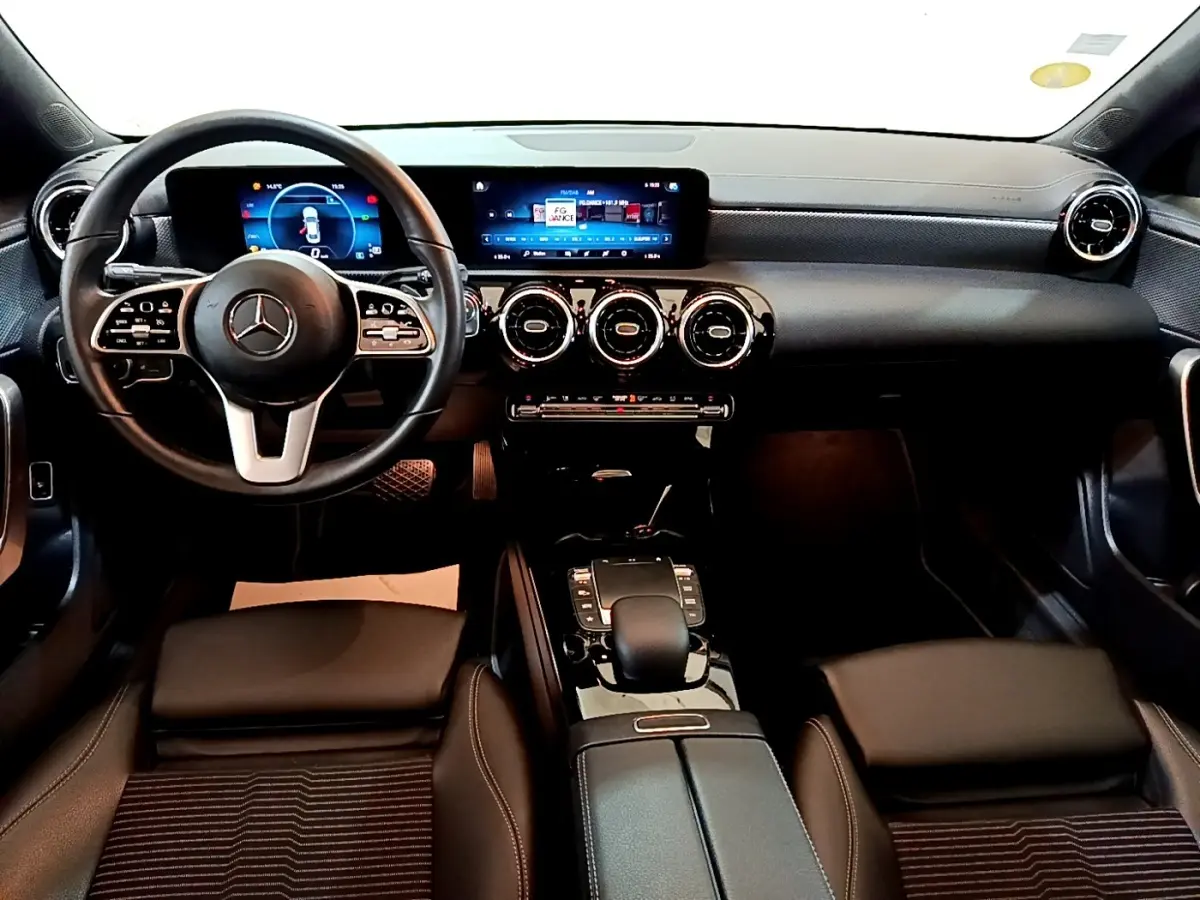 Vue intérieure avant de la Mercedes CLA 180 d Business Line 2021, tableau de bord noir avec écran tactile panoramique et volant multifonctions cuir alu.