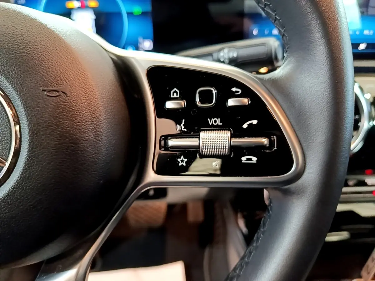 Gros plan sur le côté droit du volant cuir et alu de la Mercedes CLA 180 d Business Line 2021 avec commandes multifonctions.