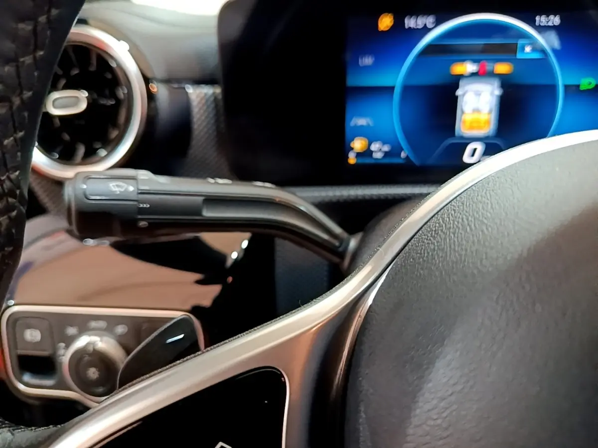 Gros plan sur le volant cuir et alu de la Mercedes CLA 180 d 2021 avec tableau de bord numérique et commandes multifonctions.