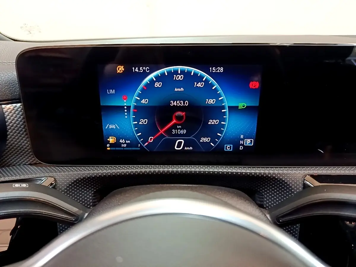 Vue intérieure centrée sur le tableau de bord numérique bleu et noir de la Mercedes CLA 180 d Business Line blanche.