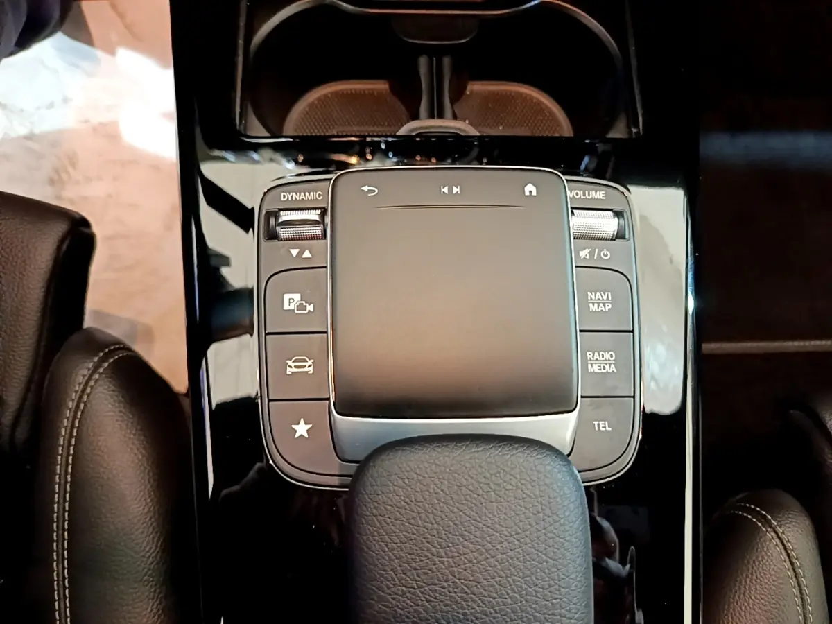 Vue rapprochée du pavé tactile central noir brillant et des boutons de commande du Mercedes CLA 180 d Business Line 2021.