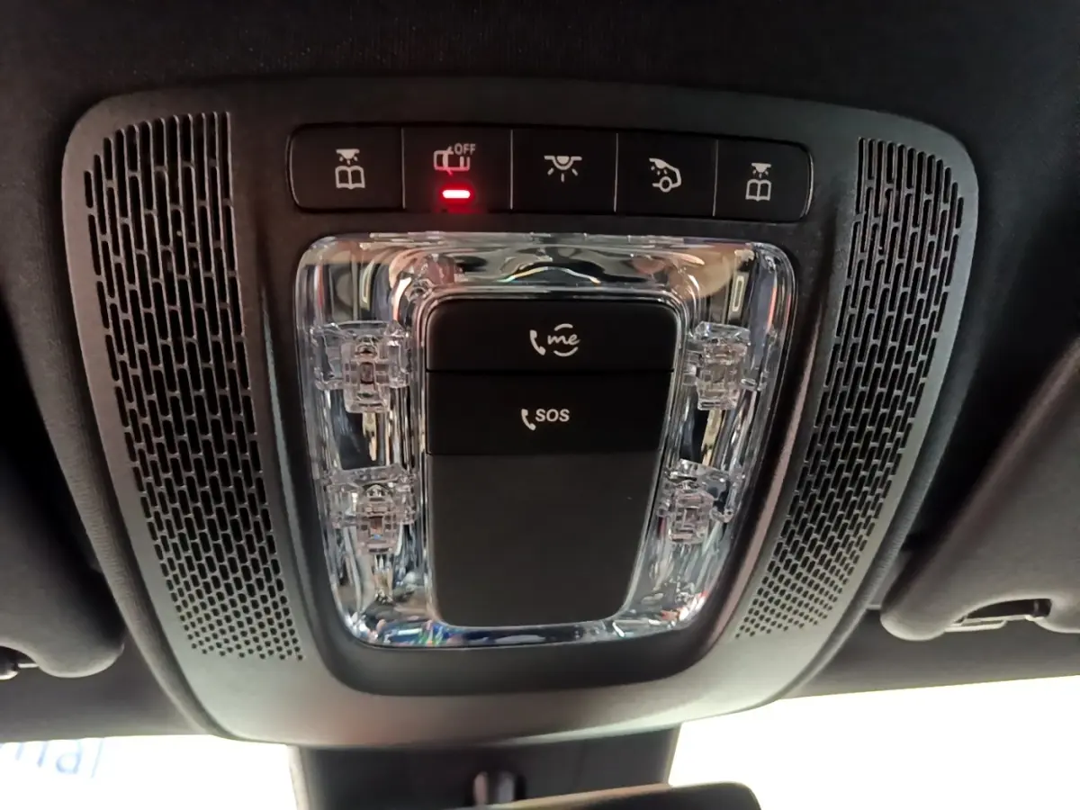 Vue en contre-plongée du plafonnier noir avec boutons SOS et appel d'urgence dans une Mercedes CLA 180 d blanche.