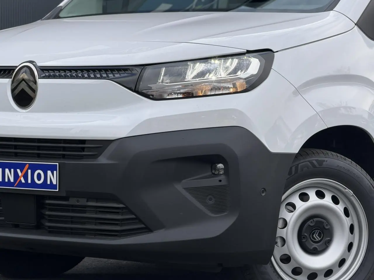 Vue 3/4 avant droit du Citroën Berlingo Van XL blanc Icy avec pare-chocs noir mat et jante tôle grise.