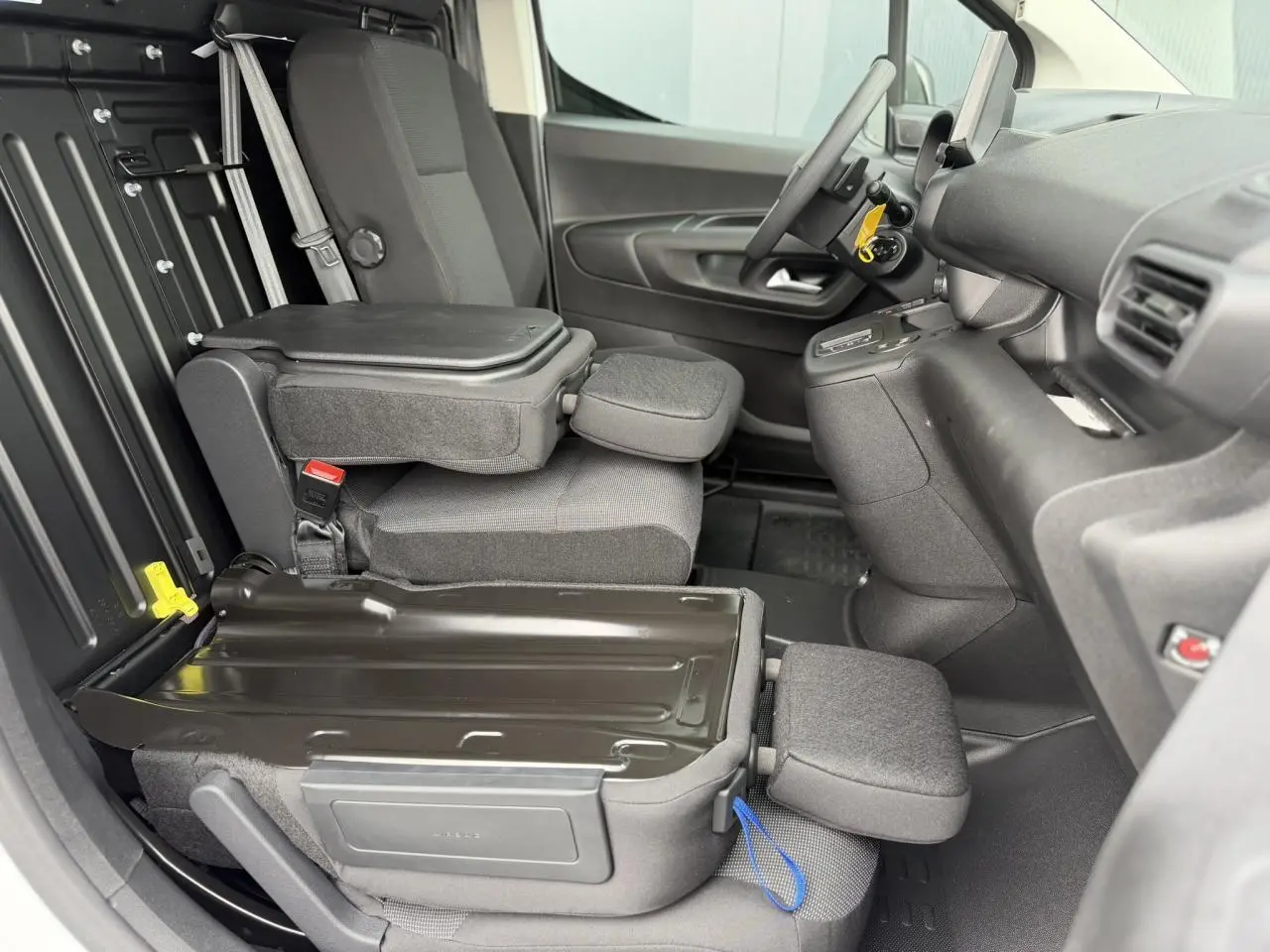 Intérieur côté conducteur du Citroën Berlingo Van XL 2026, siège rabattable avec plancher bois visible en arrière-plan.