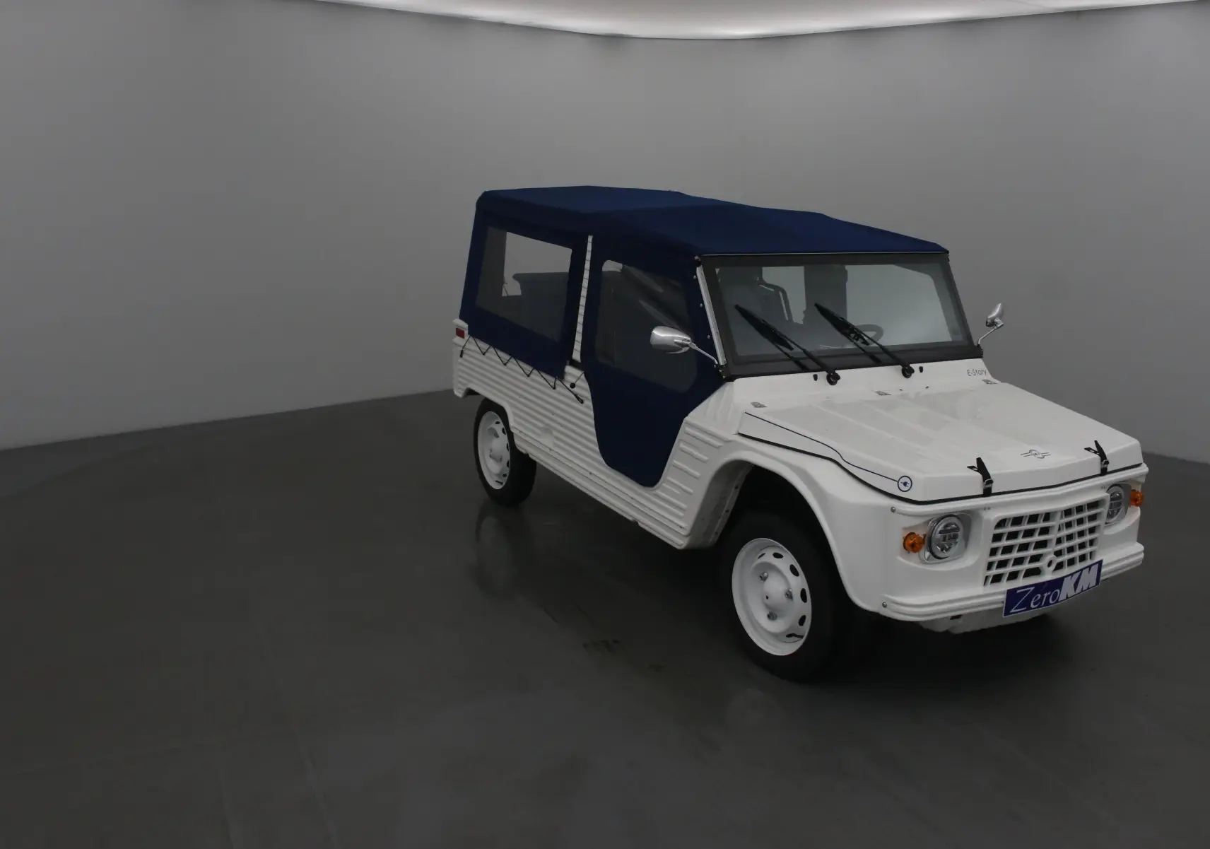 Vue 3/4 avant droite du MLT E-STORY ICONE blanc avec toit et portes souples bleu marine, jantes blanches classiques.