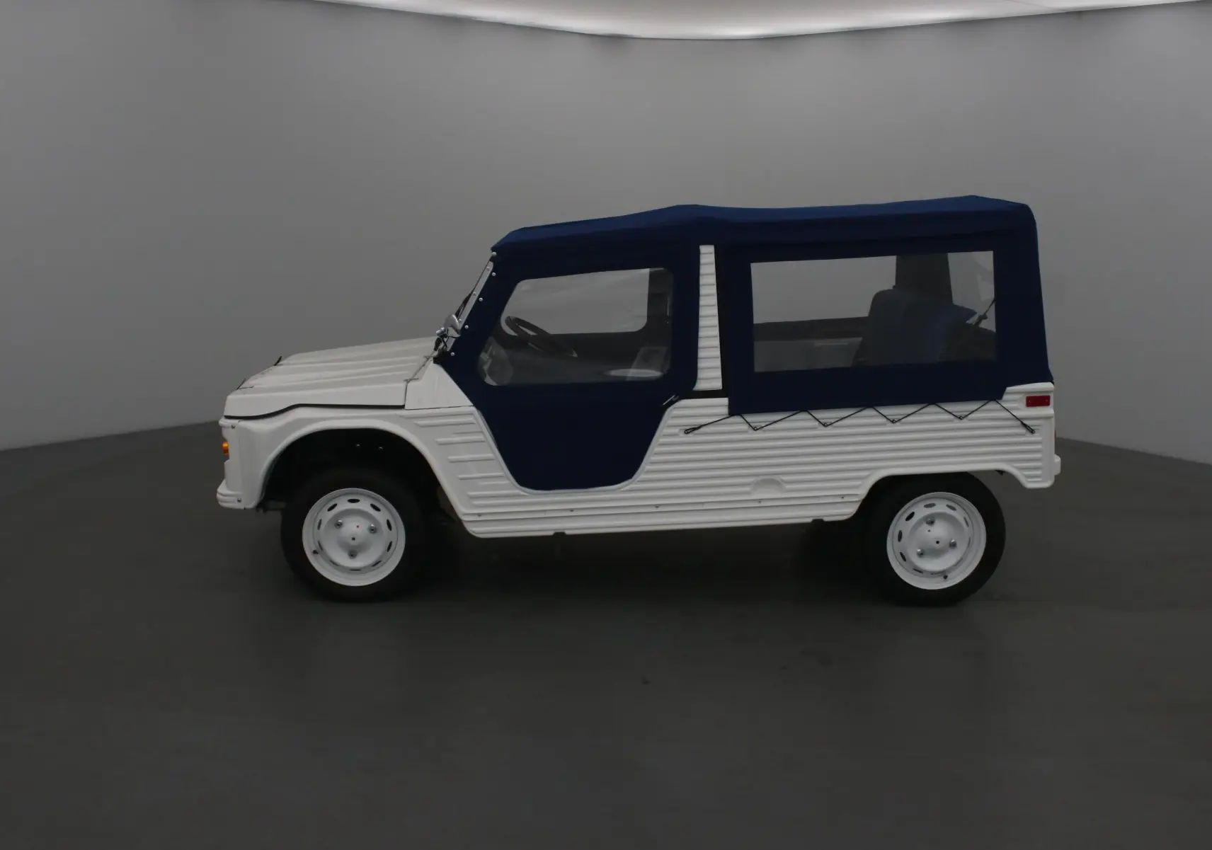 Profil droit du MLT E-STORY ICONE 2024 blanc avec toit et portes souples bleus, jantes acier blanches et style Méhari électrique.