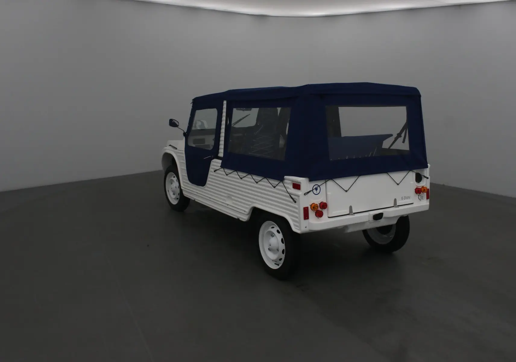 Vue 3/4 arrière droite du MLT E-STORY ICONE blanc avec toit et portes souples bleu marine.